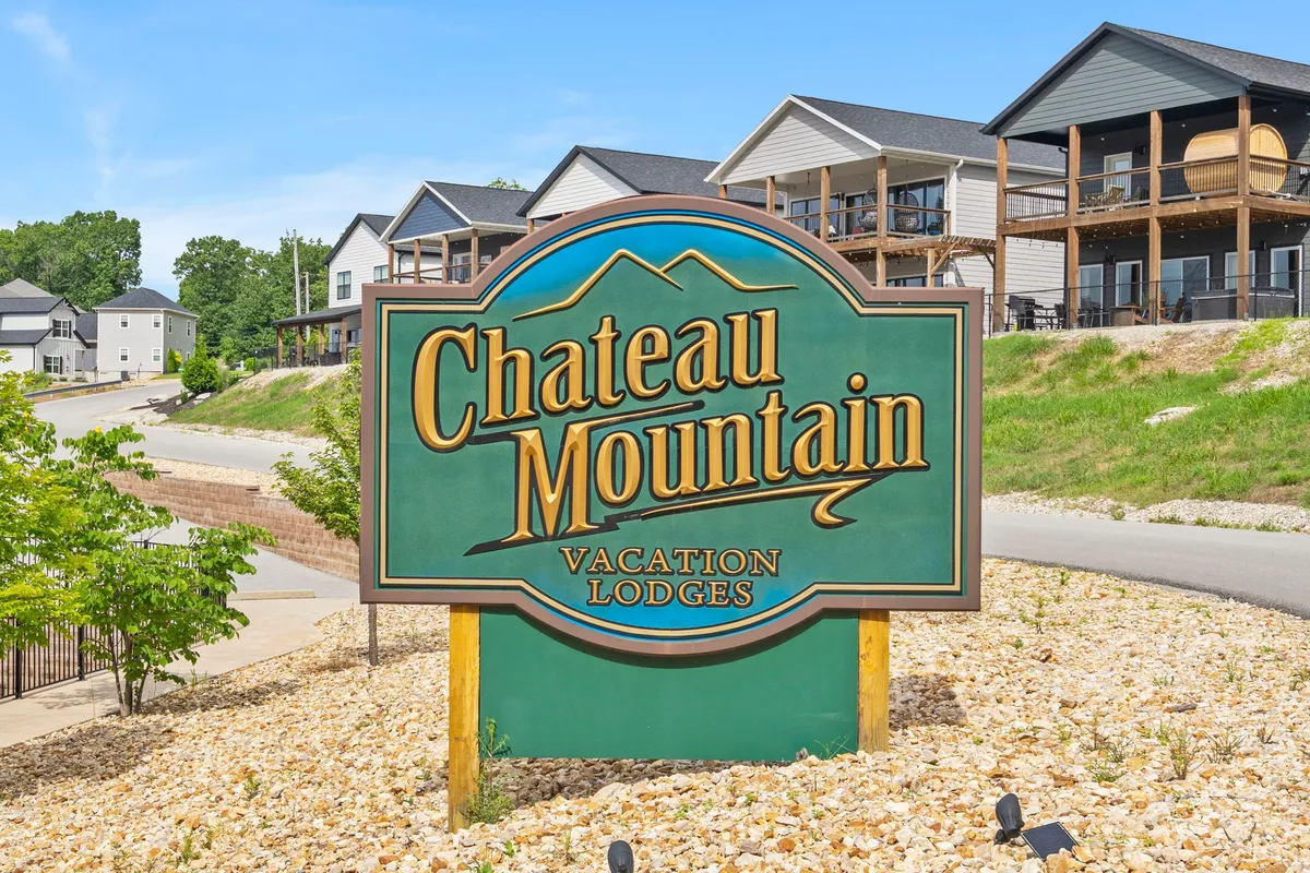 A welcoming view of the Chateau Mountain sign surrounded by well-kept landscaping and nearby lodges, establishing the property’s connection to its scenic mountain community and proximity to area activities.
