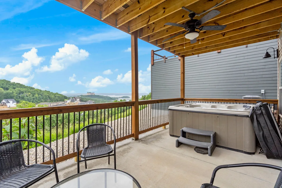 This image features a serene outdoor hot tub with a seating area, offering a sweeping view of the surrounding hills and expansive sky. The setting is tranquil, inviting guests to unwind while soaking in the warm water and taking in the natural scenery.