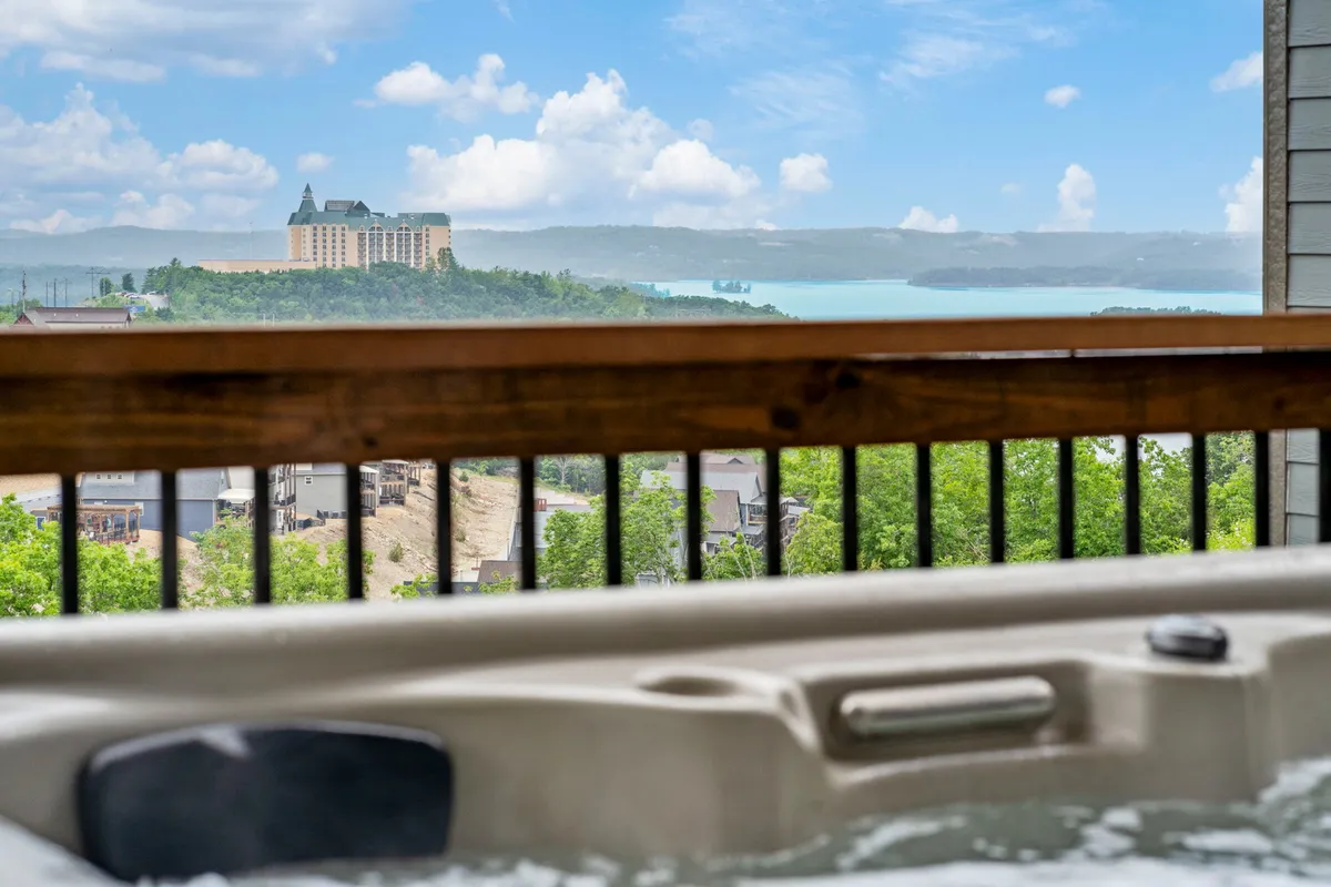 This image shows a serene outdoor hot tub positioned to overlook Table Rock Lake and the distant landscape, inviting guests to unwind while soaking in beautiful water views. The setting captures the relaxation and luxury awaiting after a day of adventures.